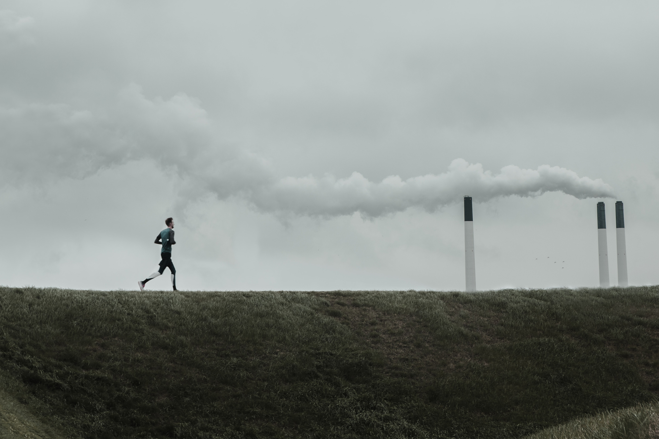 Man running in front of coal plant