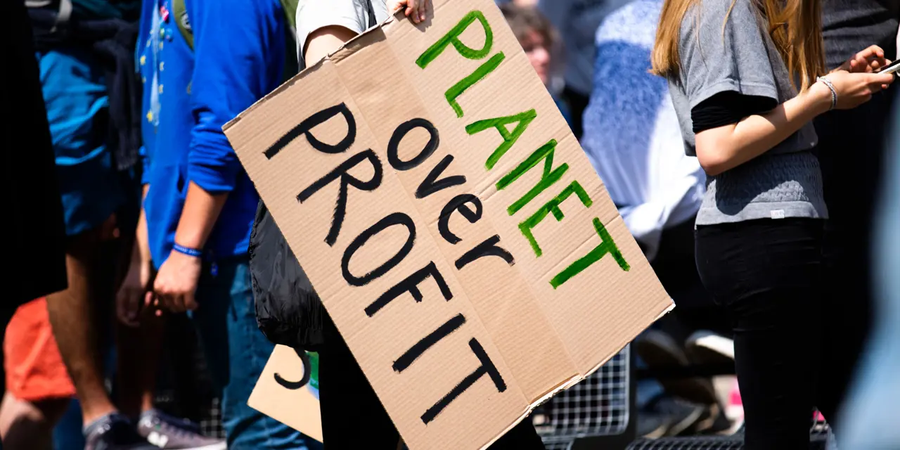 Climate protest with sign reading: people over profit